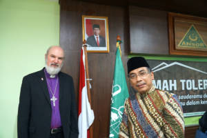 President of the International Council of the ISHR, Bishop Thomas Schirrmacher, stands with Nahdlatul Ulama General Secretary Yahya Cholil Staquf in front of the Indonesian and NU flags © BQ/Martin Warnecke